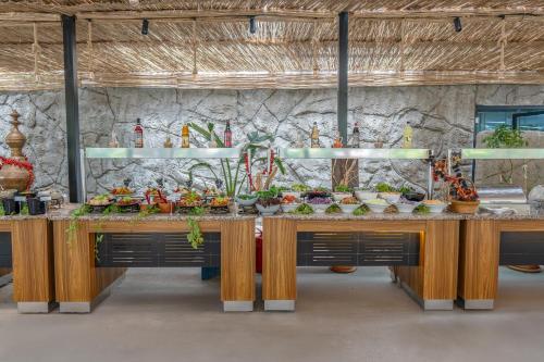 a kitchen with two tables filled with food at Golden Sun Hotel Adult Only in Beldibi