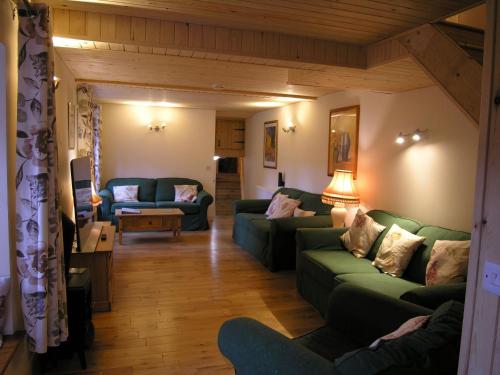 a living room with two green couches and a table at Selworthy- Ukc4915 in Timberscombe