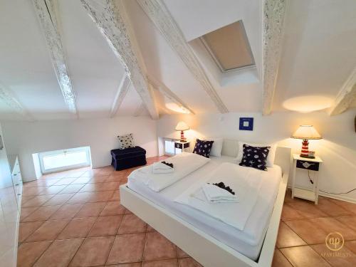 a large bedroom with a white bed and two lamps at Apartment Blue Whale in Piran