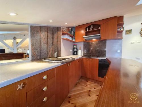 a kitchen with wooden cabinets and a sink at Apartment Blue Whale in Piran