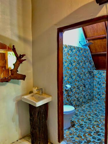 a bathroom with a sink and a toilet at Sumatra Thomas Leaf Monkey Guesthouse & Jungle Trek in Bukit Lawang