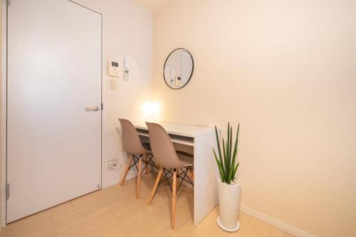 a dining room with a table and chairs and a mirror at BK Residence Kawasaki in Kawasaki