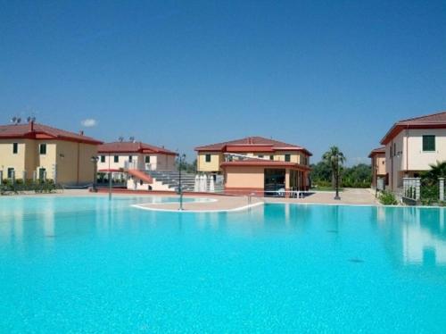 a large pool of blue water in front of buildings at Afrodite Home in Solfara Mare