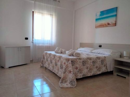 a bedroom with a bed and a large window at Afrodite Home in Solfara Mare