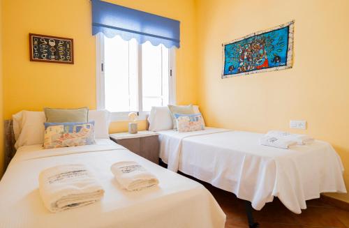 two beds in a room with yellow walls at La terraza de Albatros in La Isleta del Moro
