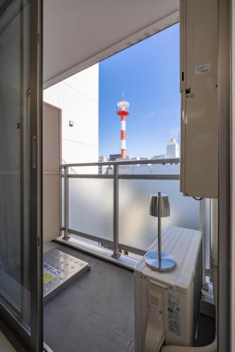 a room with a view of a lighthouse from a balcony at BK Residence Kawasaki in Kawasaki