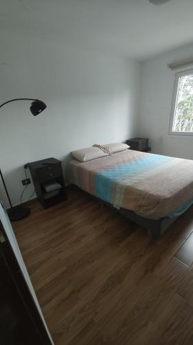a bedroom with a bed and a wooden floor at Casa de Ushuaia in Ushuaia