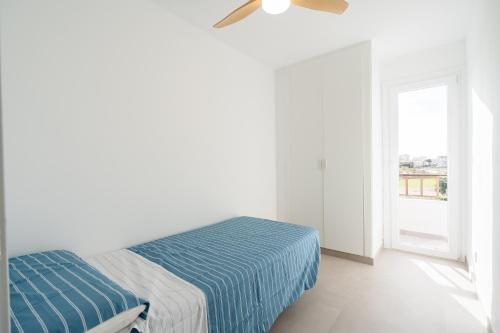 a white room with a bed and a window at Casa Ingravita - Oceanfront Tranquility in Cunit