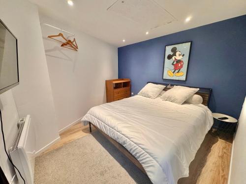 a bedroom with a bed with a blue wall at Maison cosy - 4 pers - Disney & Route du Champagne in Citry