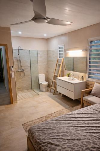 a bathroom with a bed and a tub and a sink at Évasion Caraïbes in Ducos