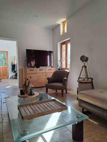 a living room with a couch and a glass table at L'Echo de la Nature in Sasseville