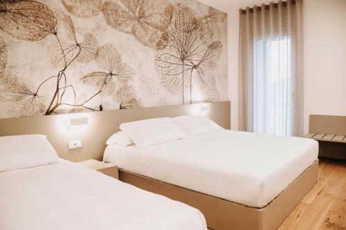 a bedroom with two beds and a wall mural at Ca' Perenzin in Tarzo