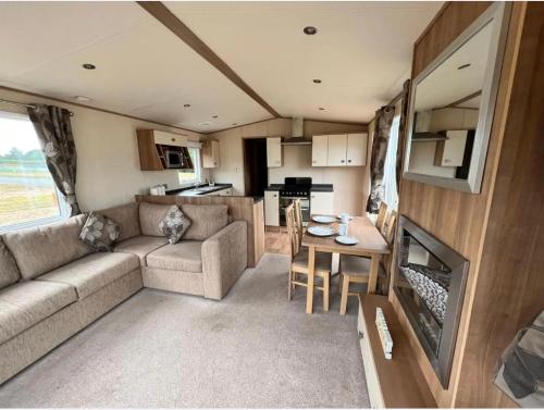 an rv living room with a couch and a table at 9 Sea View Kessingland Beach Parkdean Resorts MIN 3 NIGHT STAY in Kessingland