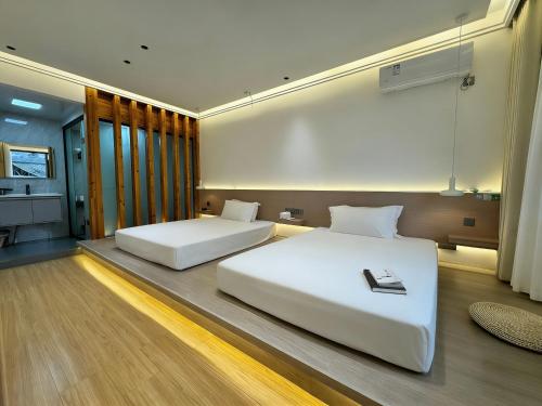 two beds in a hotel room with at 枫江月 in Fenghuang County