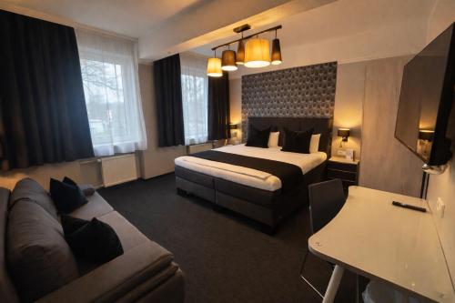 a hotel room with a bed and a couch at Arena Hotel in Gelsenkirchen