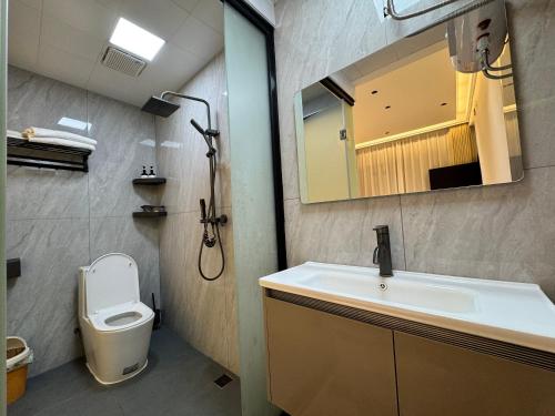 a bathroom with a sink and a toilet and a mirror at 枫江月 in Fenghuang County
