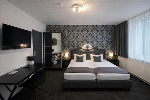 a bedroom with a large bed with a desk and a bed sidx sidx sidx sidx at Arena Hotel in Gelsenkirchen