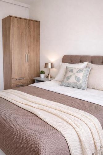 a bedroom with a large bed with a wooden cabinet at Verdant Comfort Apartment in Moka