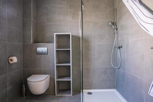 a bathroom with a shower and a toilet and a sink at La Casa Motel in Schaafheim