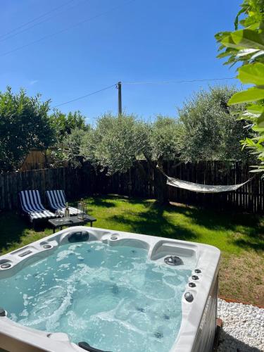 a hot tub in a yard with two chairs at Agriturismo Colle Salomonio in Nepi