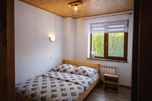 a small bedroom with a bed and a window at Leśny Dwór Bieszczady in Ustrzyki Dolne