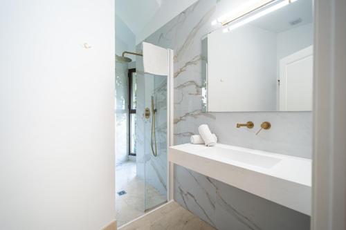 a white bathroom with a sink and a mirror at GAV Santa Pola in Ronda