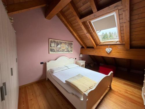 a bedroom with a white bed in a attic at Appartamento bambi abetone in Abetone