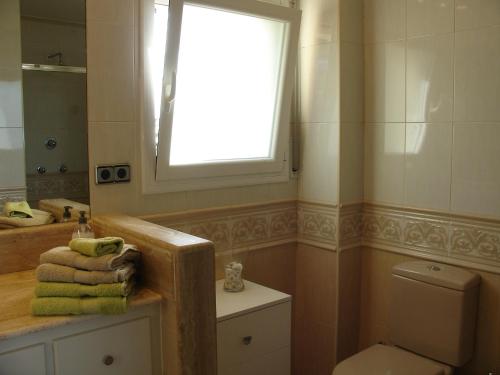 baño con ventana, lavabo y aseo en Villa Gardenia mit Pool und traumhaftem Meerblick, en Santa Cristina d'Aro