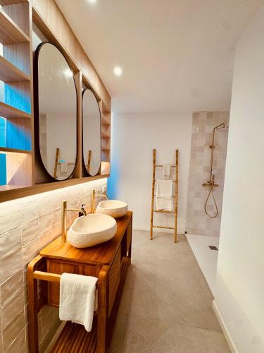 a bathroom with two sinks and two mirrors at Apartaments La Perla Negra in Cala Ratjada