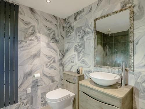 a bathroom with a sink and a toilet and a mirror at 3 Bed in Belford oc-78057 in Ellington