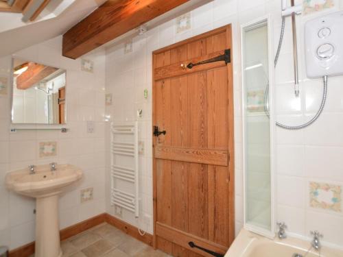 a bathroom with a wooden door and a sink at 2 Bed in Matlock oc-75893 in Smalley