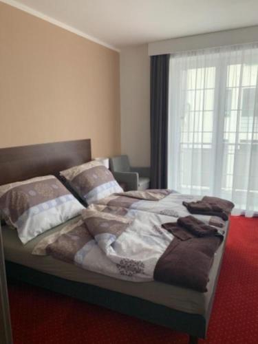 a bedroom with a large bed with a red carpet at Wellness hotel Harmonie Třeboň in Třeboň