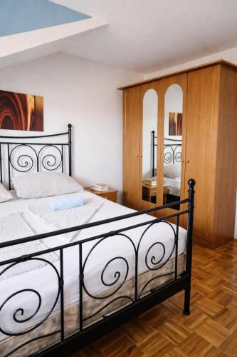 a bedroom with a large bed and two mirrors at Orange city apartment's Repić in Biograd na Moru