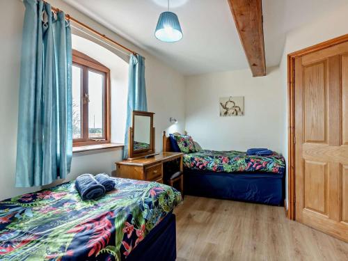 a bedroom with two beds and a mirror at 3 Bed in Ellesmere oc-94419 in Dodleston