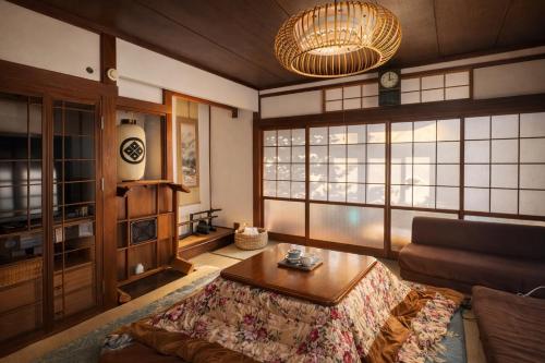 a living room with a couch and a table at Nagasaki Horigotatsu Kominka Stay 掘りごたつの古民家1棟貸切 in Nagasaki