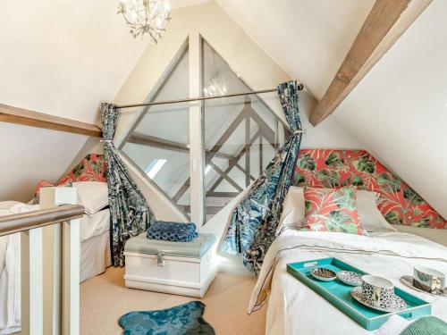 a attic bedroom with a bed and a chandelier at 2 Bed in Ashbourne oc-89339 in Edwalton
