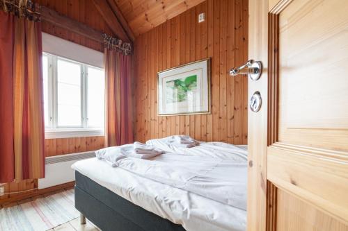 a bedroom with a bed and a window in it at Valen Cabins in Reine in Reine