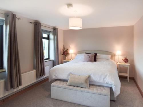 a bedroom with a large white bed and two windows at 1 Bed in Lydney oc-73584 in Saint Briavels