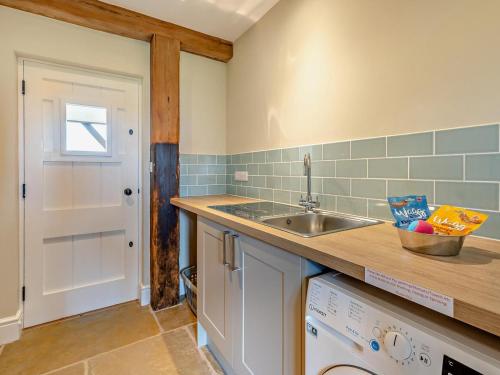 a kitchen with a sink and a washing machine at 1 Bed in Bucknell oc-94662 in Letton
