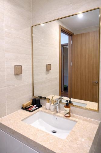 a bathroom with a sink and a large mirror at BRG Luxury Apartments in Hai Phong