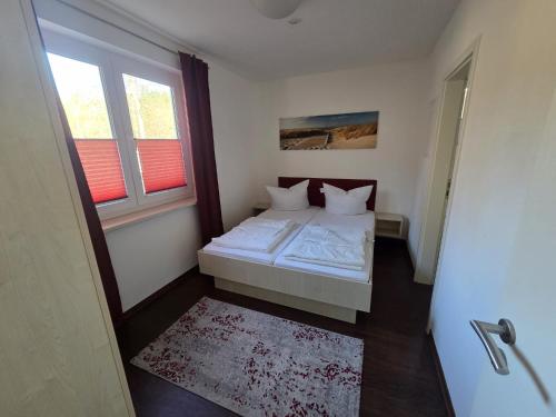 a small bedroom with a bed and a window at Seeschwalbe in Graal-Müritz