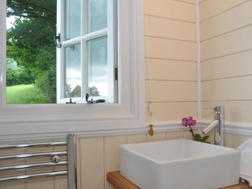 a white sink in a bathroom with a window at 1 Bed in Hereford oc-44235 in Longtown