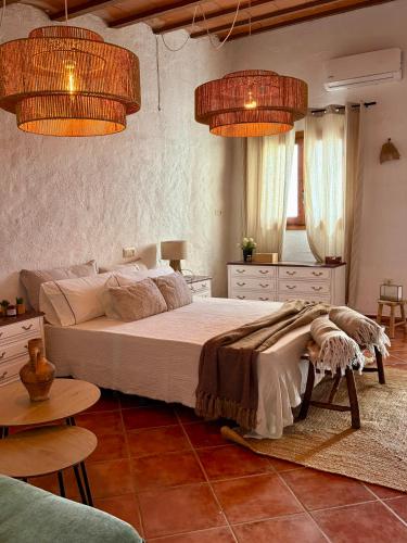 a bedroom with a large bed and two lights at Casa Rural La Font in Sant Mateu
