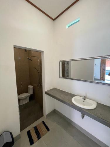 a bathroom with a sink and a toilet at Raditya Homestay in Mambat