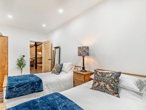 a bedroom with two beds and a lamp on a table at 2 Bed in High Peak oc-94059 in New Mills