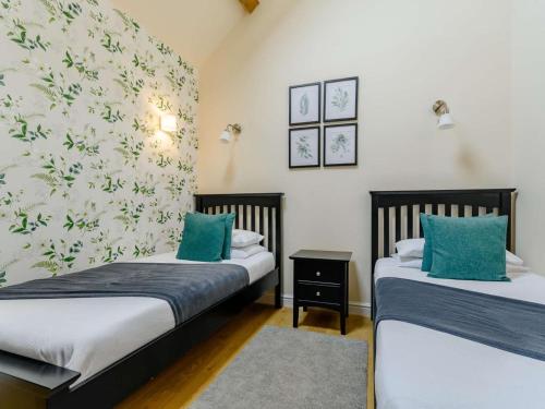 two beds in a room with green pillows at 2 Bed in Evesham oc-89305 in Church Lench