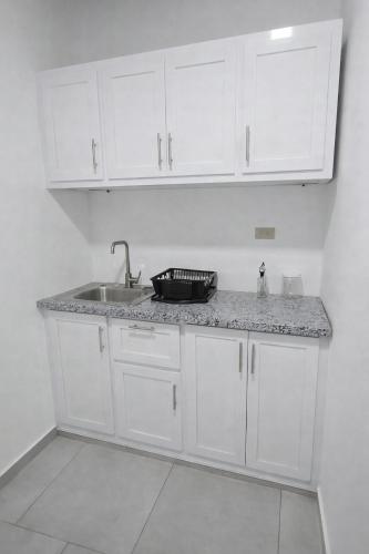 a kitchen with white cabinets and a sink at GK Luxury Stay in Cruce de Veragua