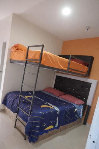 two bunk beds in a room with a ladder at GK Luxury Stay in Cruce de Veragua