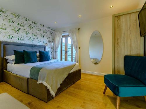 a bedroom with a bed with blue pillows and a chair at 1 Bed in Evesham oc-89306 in Church Lench