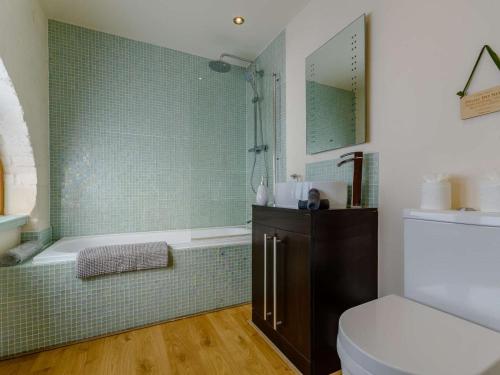 a bathroom with a tub and a toilet and a sink at 1 Bed in Evesham oc-89306 in Church Lench